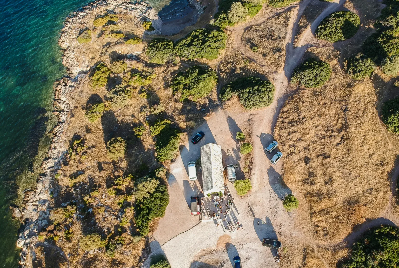 aerial view of a beach with a group of cars and a building