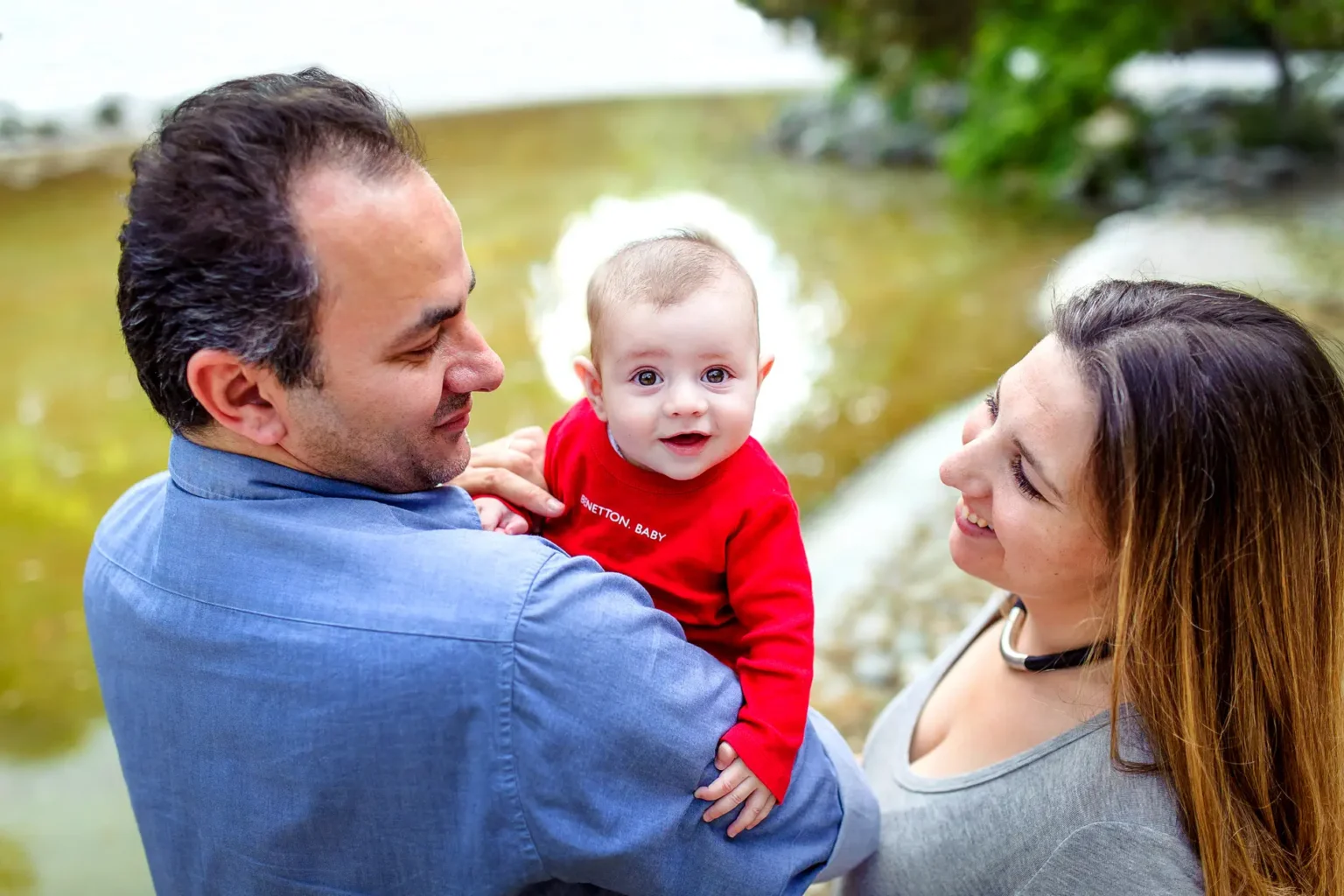 a man and woman holding a baby