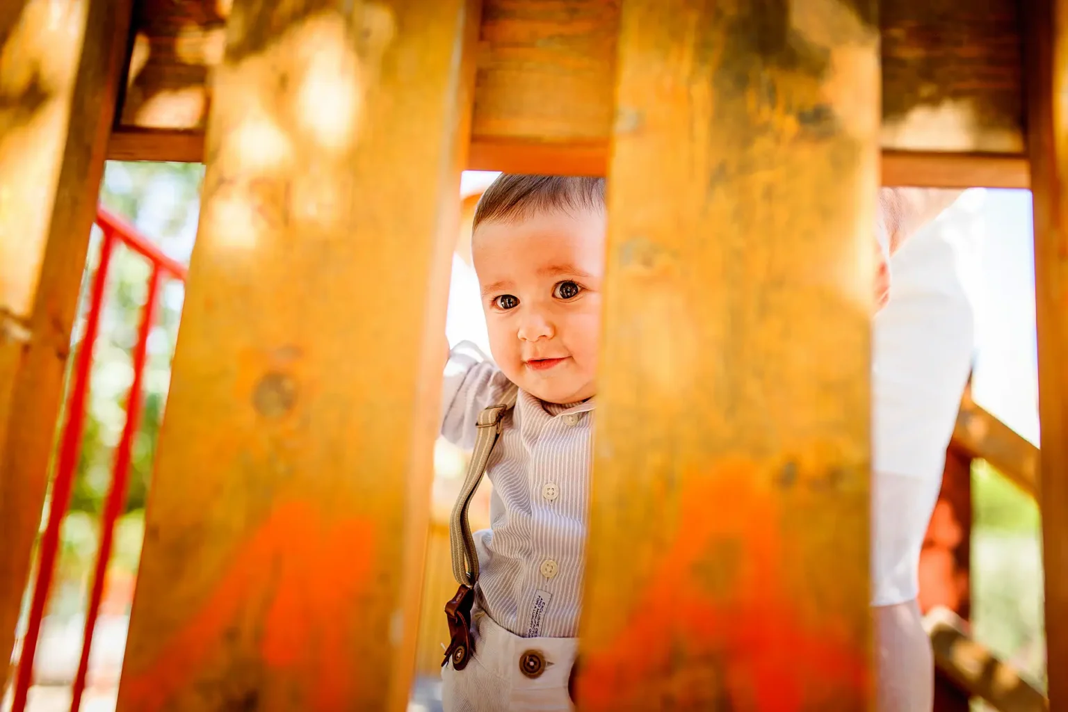 a baby looking through a fence